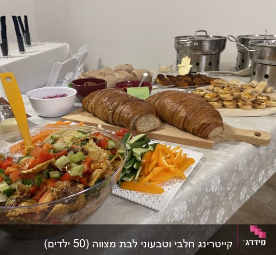 שולחן קייטרינג עם סלט, לחם, ירקות ומאפים